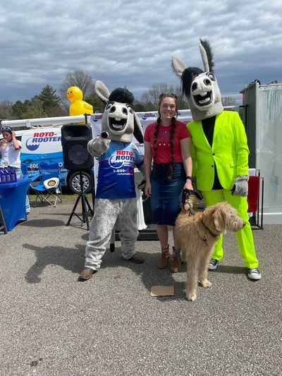 Two people in Mule costumes posing with a local at the annual Muletown festival