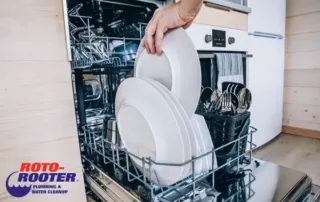 Woman Placing dishes to dishwasher - Roto-Rooter Plumbing Columbia TN Logo