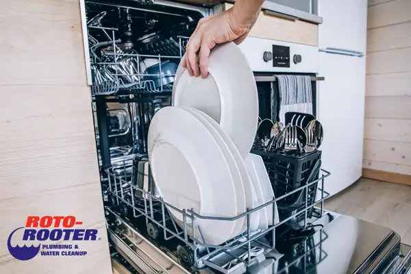 Woman Placing dishes to dishwasher - Roto-Rooter Plumbing Columbia TN Logo
