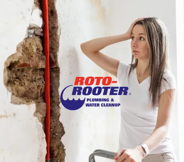 Woman scratcin her head watching red exposed pipe. Roto-Rooter Plumbing