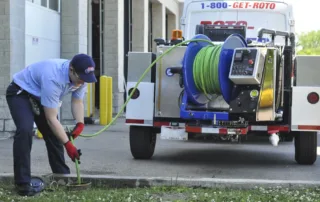 A man is using a hydro jetting to clean the drain