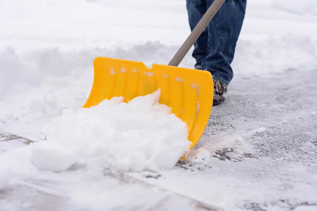 Shoveling Snow on a cold winter day with a yellow snow shovel